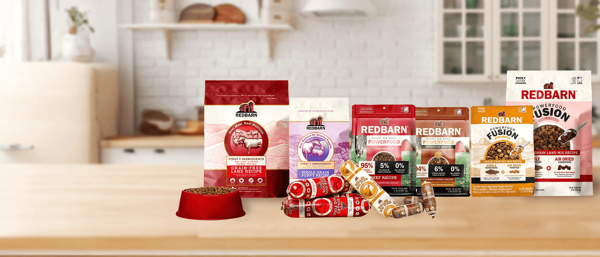 Assorted Redbarn pet food packages on a kitchen counter with a blurred background
