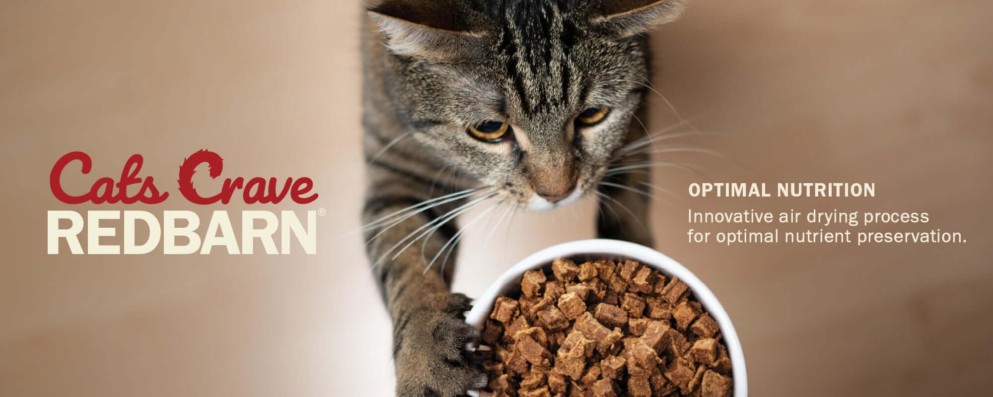 Cat's Crave Redbarn cat food with a cat holding a bowl of food against a beige background