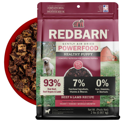 Redbarn Gently Air Dried Powerfood Healthy Puppy Beef & Lamb Recipe with a bowl of the Air Dried Food in the back on a white background