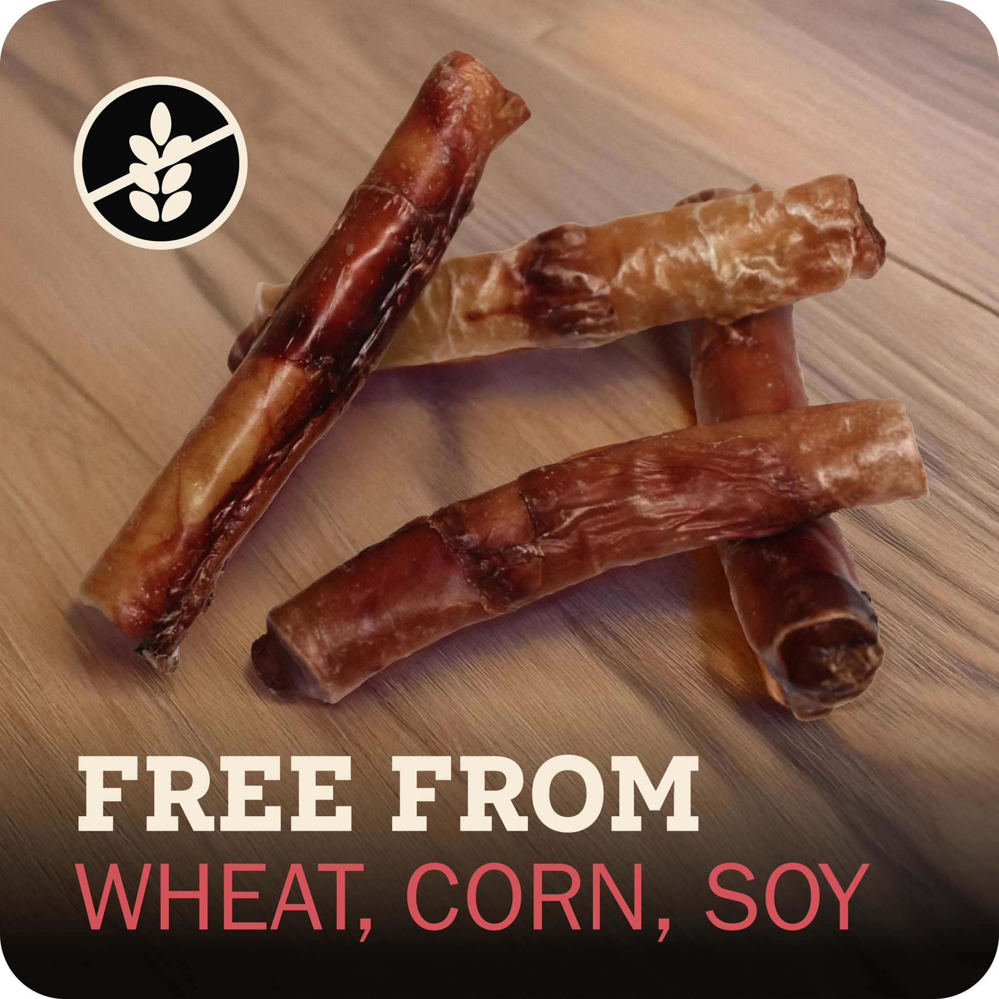 Four Redbarn Monster Bully arranged on a wood surface, with a black circular wheat-free icon in the top left and text at the bottom reading 'FREE FROM WHEAT, CORN, SOY'.